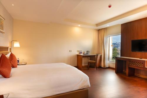 Habitación de hotel con cama grande y escritorio. en Hotel Dragon Leh, en Leh