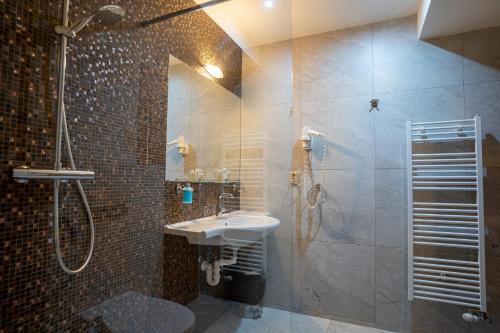 a bathroom with a sink and a shower at Hotel Strachanovka - Jánska Koliba in Liptovský Ján