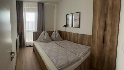 a bedroom with a bed with a wooden head board at Apartman Valnela in Veľká Lomnica