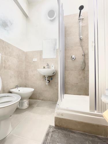 a bathroom with a shower and a toilet and a sink at Romoli Rooms and suites in Rome