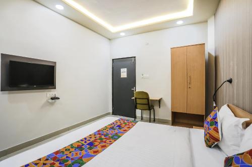 ein Hotelzimmer mit einem Bett und einem TV in der Unterkunft FabHotel Convivial Sky in Raipur