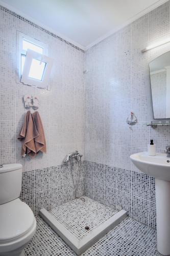 a bathroom with a toilet and a sink at Villa Sotiria in Néa Thésis
