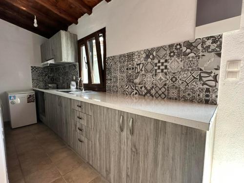 a kitchen with wooden cabinets and a counter top at Villa Nikos Koukounaries in Koukounaries