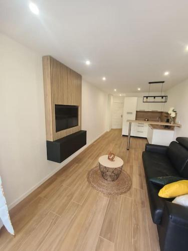 un salon avec un canapé noir et une table dans l'établissement superbe appartement proche mer, à Menton