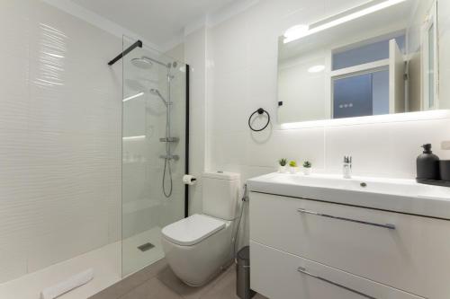 ein weißes Bad mit einem WC und einer Glasdusche in der Unterkunft Callao sunset apartment, sea view and pool in Callao Salvaje