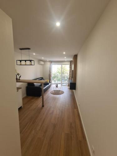 un salon vide avec une table et un bureau dans l'établissement superbe appartement proche mer, à Menton