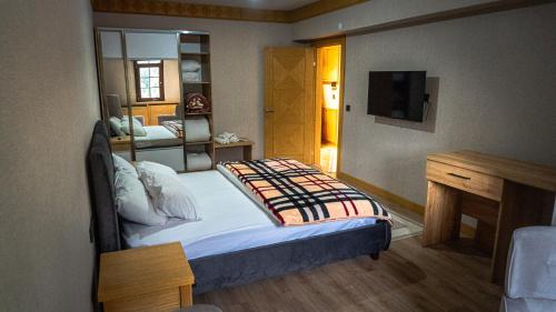 a bedroom with a bed and a television in it at Ayder Elif Apart Daire in Ayder Yaylasi