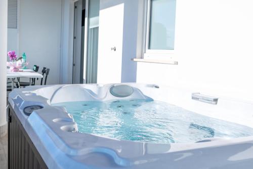 a jacuzzi tub in a bathroom with a table at I Bordin Home in Nettuno