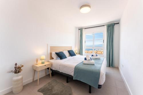 ein Schlafzimmer mit einem Bett und einem großen Fenster in der Unterkunft Callao sunset apartment, sea view and pool in Callao Salvaje