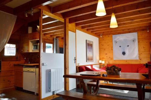 une cuisine avec une table et un réfrigérateur blanc dans l'établissement Chalet Bippo Pyrénées 2000 WiFi fibre, à Bolquère-Pyrénées 2000