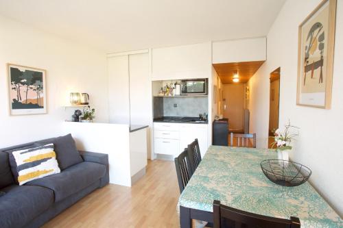 ein Wohnzimmer und eine Küche mit einem Sofa und einem Tisch in der Unterkunft Capbreton - CERS - Plage - Famille - Couple in Capbreton