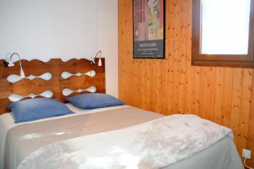 une chambre avec un lit avec des oreillers bleus dans l'établissement Chalet Bippo Pyrénées 2000 WiFi fibre, à Bolquère-Pyrénées 2000