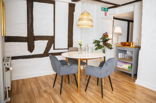 a dining room with a table and four chairs at Hotel Hamlet in Helsingør