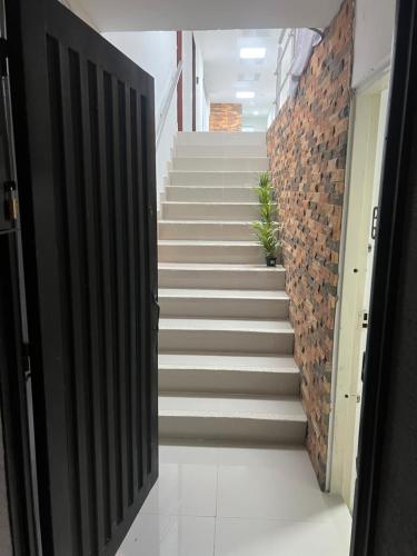 a staircase in a building with white floors and a brick wall at Hotel Coffee Real Pereira in Pereira