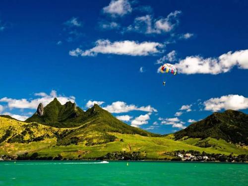 a kite flying in the sky over a mountain at Paradisia Holidays Mauritius in Trou dʼ Eau Douce