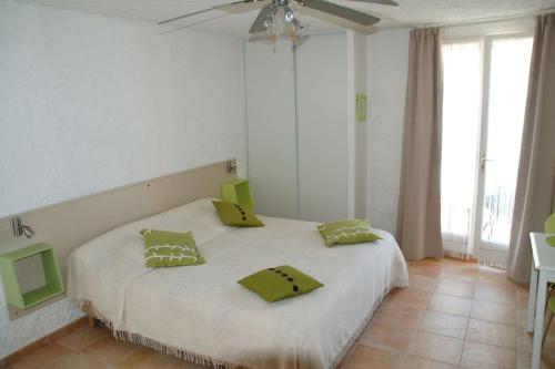 - une chambre avec un lit doté de 2 oreillers jaunes dans l'établissement Charmant studio sur le port, à Kamiesch