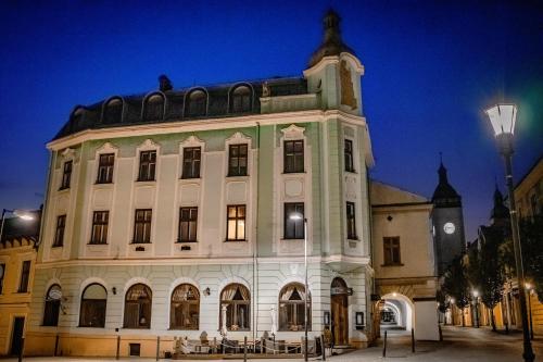 un gran edificio con una torre de reloj por la noche en Hotel Růžek en Hranice