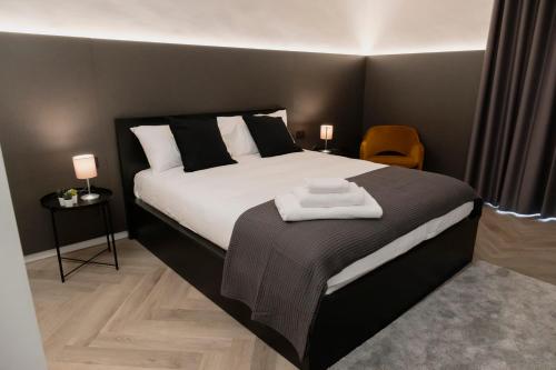 ターラントにあるbarneys design apartmentのベッドとタオル2枚のある寝室