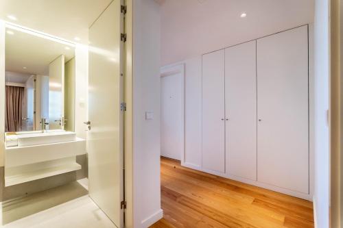 baño con armarios blancos y espejo en Beachfront Garden & SPA - indoor and outdoor pool, en Armação de Pêra