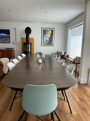 a dining room with a large wooden table and white chairs at Frinton45 in Frinton-on-Sea