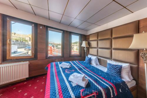 um quarto com uma cama num quarto com janelas em Botel Albatros em Praga