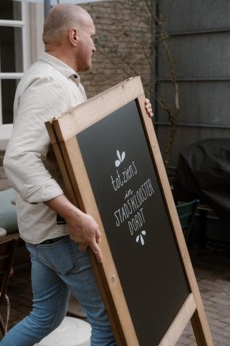 a man is standing next to a chalkboard at Stadsklooster Dordt Hotel&Hostel in Dordrecht