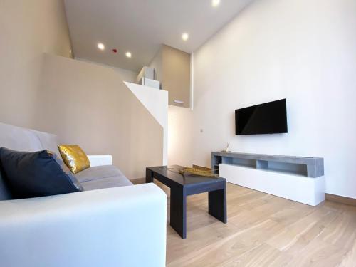 a living room with a couch and a tv on a wall at Miami Apartments in St. Julianʼs