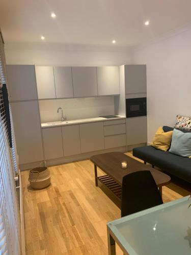 uma sala de estar com um sofá e uma mesa em Beautiful one bedroom flat in the heart of Notting Hill Gate em Londres