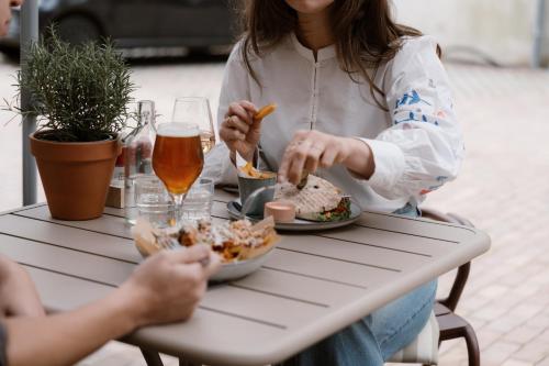 a woman sitting at a table eating food at Stadsklooster Dordt Hotel&Hostel in Dordrecht