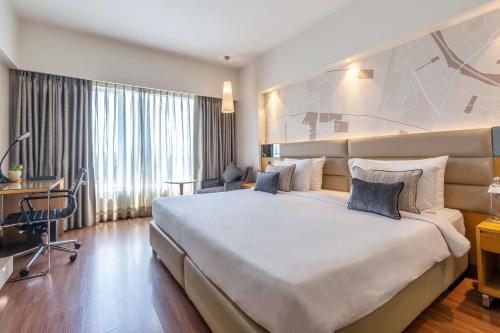 um quarto de hotel com uma cama grande e uma secretária em The Fern - Goregaon em Mumbai