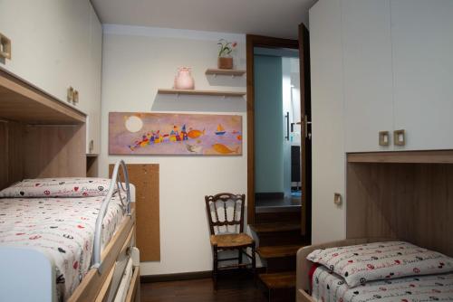 Casa Bia في بورليتسا: غرفة نوم بسريرين وكرسي ودهان