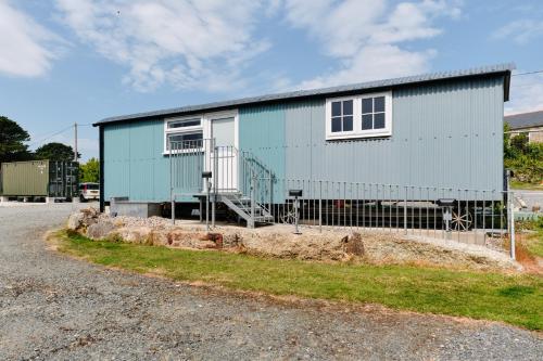 a blue house with a fence in front of it at Mount View Overnight Accommodation in Penzance