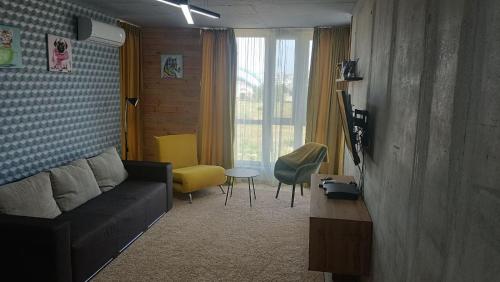 ein Wohnzimmer mit einem Sofa und einem Tisch in der Unterkunft Smart apartment in Juschne