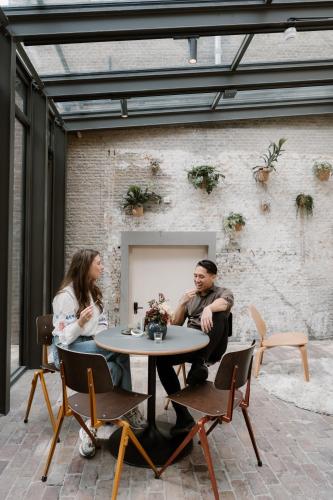 two people sitting at a table in a patio at Stadsklooster Dordt Hotel&Hostel in Dordrecht