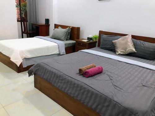 a bedroom with two beds with a stuffed animal on it at Orchid 101 in Kampot