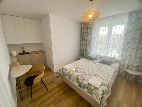 Cet appartement comprend une chambre avec un lit et une table ainsi qu'une cuisine. dans l'établissement Miejska Stodoła, à Biała Podlaska