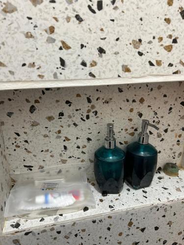 a bathroom shelf with two toothbrushes on it at Clamitan House in Padalarang