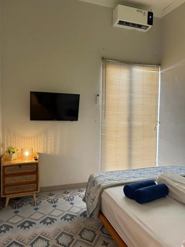 a bedroom with a bed and a tv on the wall at Clamitan House in Padalarang
