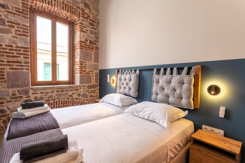 a bedroom with two beds and a window at ISSA Lesvos in Mytilini