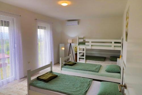 2 Etagenbetten in einem kleinen Zimmer mit Fenstern in der Unterkunft Villa Bubinka in Bihać