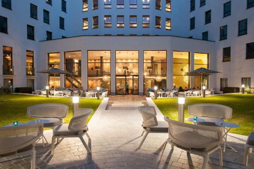 a group of chairs and tables in front of a building at Motel One Brussels in Brussels