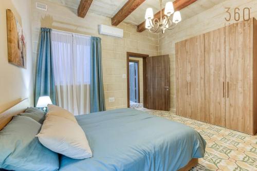 a bedroom with a large blue bed with a window at LUX Villa with Private Pool, BBQ & Rooftop Oasis by 360 Estates in Il-Wileġ