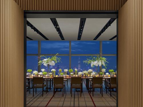 a dining room with a long table with chairs at Mandarin Oriental, Shenzhen in Shenzhen