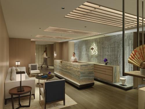 a hotel lobby with a woman standing at a counter at Mandarin Oriental, Shenzhen in Shenzhen