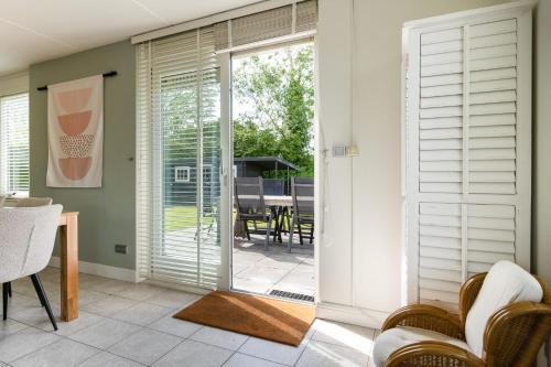 a living room with a sliding glass door leading to a patio at Hello Zeeland - Vakantiehuis Dunen260 in Breskens