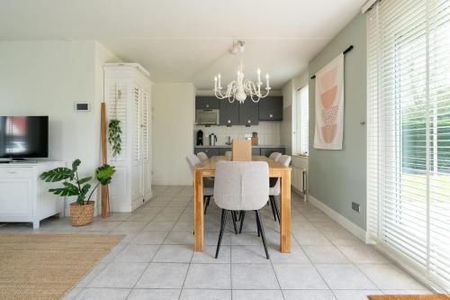 a dining room and kitchen with a table and chairs at Hello Zeeland - Vakantiehuis Dunen260 in Breskens