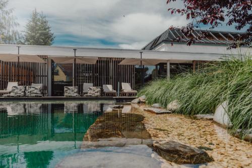 a house with a swimming pool with chairs and an umbrella at zumOXN in Laufen