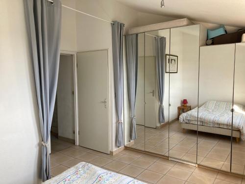 une chambre avec deux lits et un miroir dans l'établissement La mer sans voiture ! 2 e-bikes à louer, vue sublime, 40 m2, à Saint-Mandrier-sur-Mer