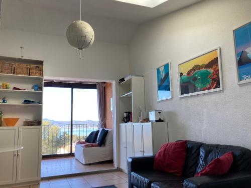 un salon avec un canapé et une grande fenêtre dans l'établissement La mer sans voiture ! 2 e-bikes à louer, vue sublime, 40 m2, à Saint-Mandrier-sur-Mer