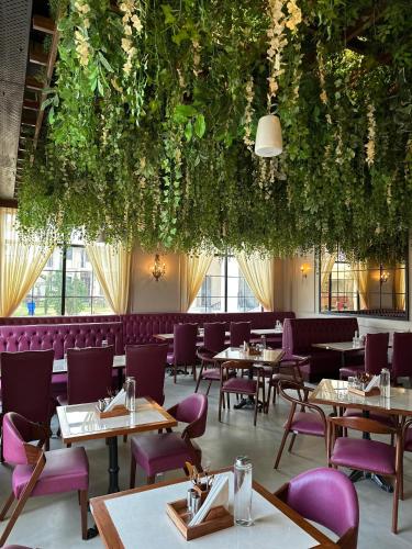 a dining room with tables and purple chairs at La Nature Hotels & Resorts in Sīkar